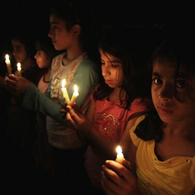 Palestinian children hold candles during a protest in Gaza City